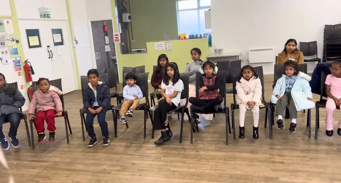 Children sitting in a circle at Kids Club