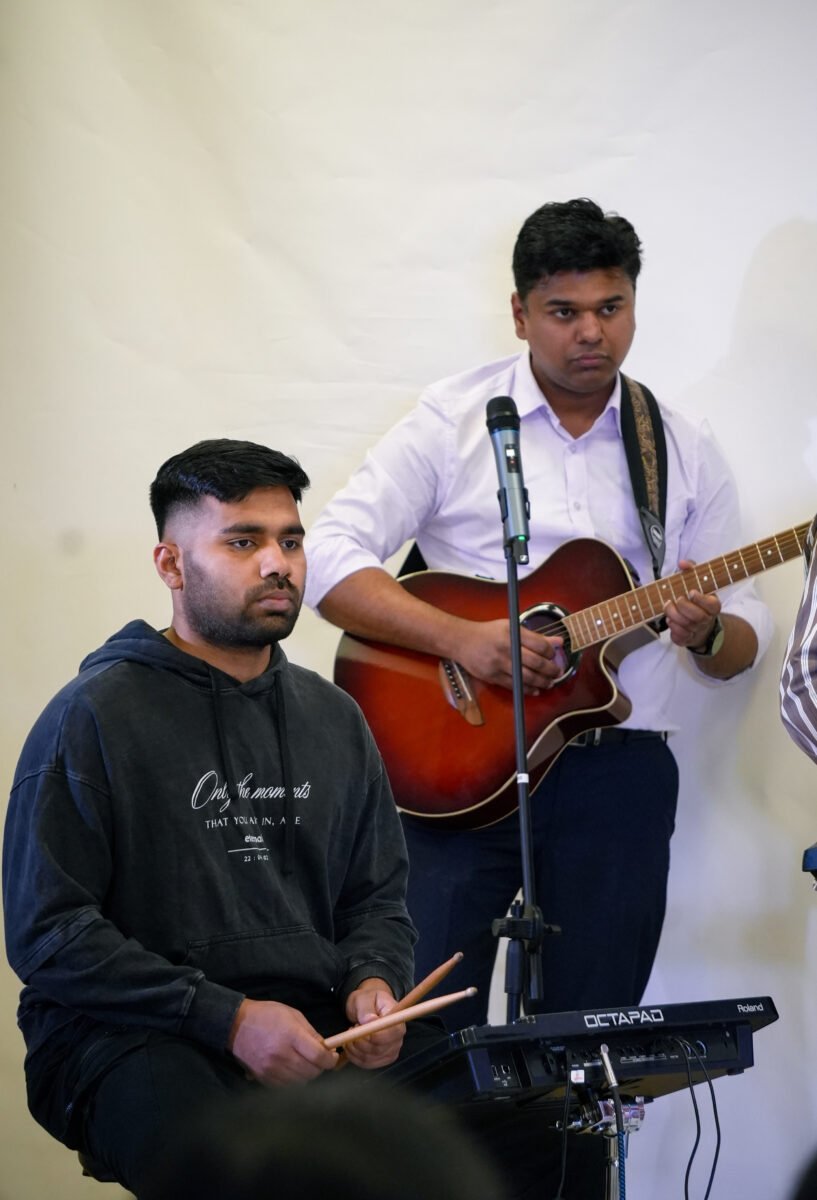 Worship leader playing guitar at a Spring Valley Church service