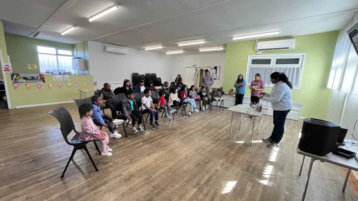 Children seated in a hall listening to leaders at Kids Club